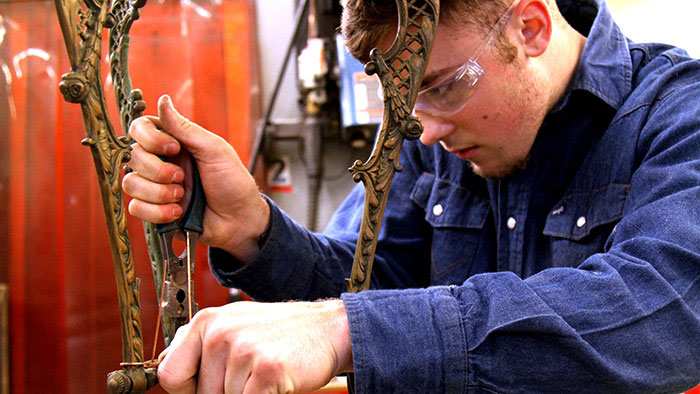 John Kunis working on historical metal plant stand